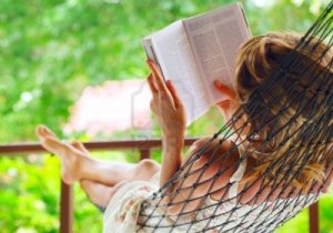9912221-young-woman-lying-in-hammock-in-a-garden-and-reading-a-book-shallow-dof-focus-on-a-left-shoulder